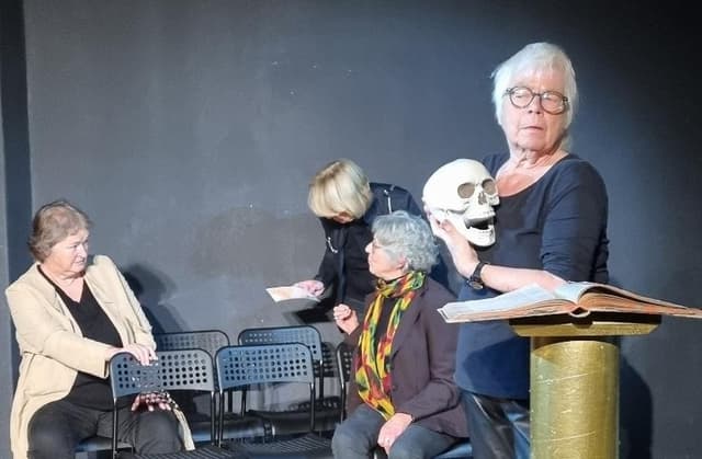 Schauspielende auf der Bühne mit goldener Säule und Totenschädel