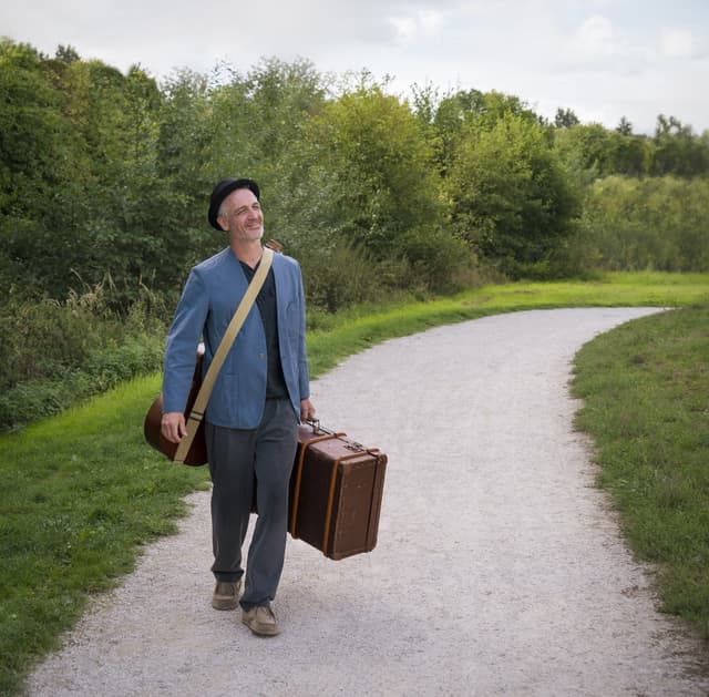 Mann mit Koffer auf der Straße