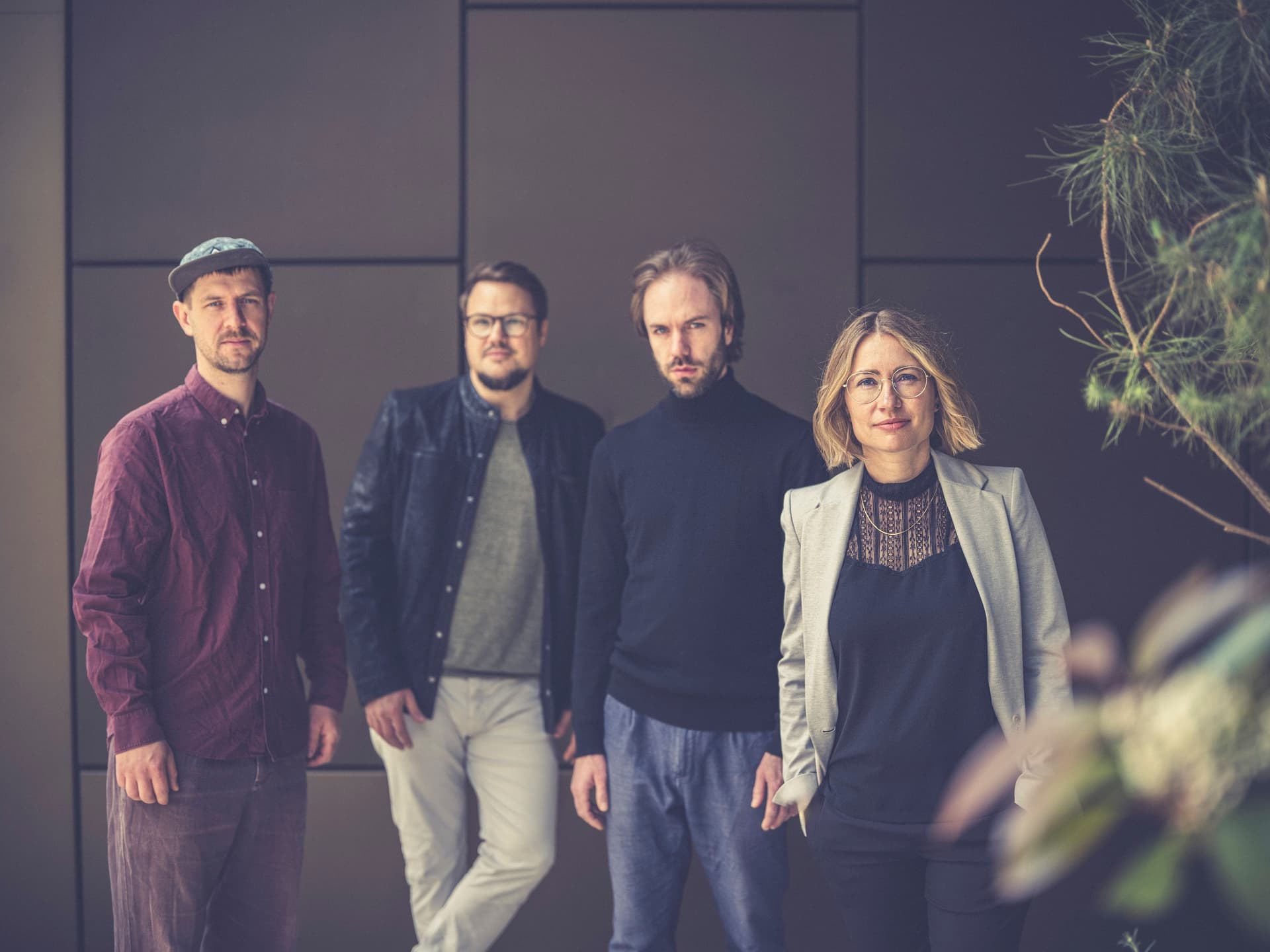 Das Rebecca Trescher Quartett steht vor einer modernen Gebäudefassade und blickt in die Kamera.