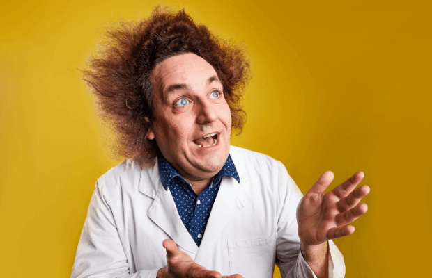 Porträt des Wissenschafts-Comedians mit wild verstrubbelten Haaren und im Laborkittel vor einem gelben Hintergrund.